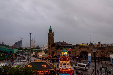 Hamburg, Almanya, 10 Mayıs. 2104 numara. Hamburg limanındaki St. Pauli Landungsbruecken. Büyük şehirde ünlü eğlenceyi ziyaret eden turistler. Tarihi saat kulesi