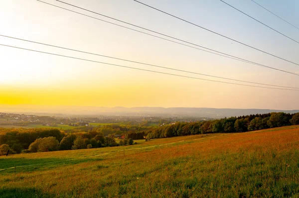 Krásné a klidné pole s elektrickými vysílači během slunečného dne — Stock fotografie