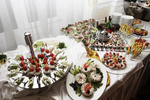 Mesa de catering cheia de alimentos apetitosos — Fotografia de Stock