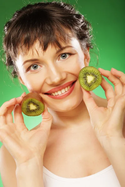 Mladý usmívající se žena hospodářství kiwi. — Stock fotografie