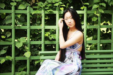 Asyalı kadın bankta oturan