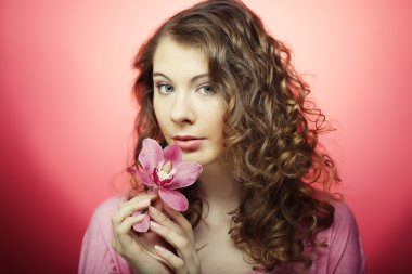 Kadın pembe bir arka plan üzerinde orkide çiçek