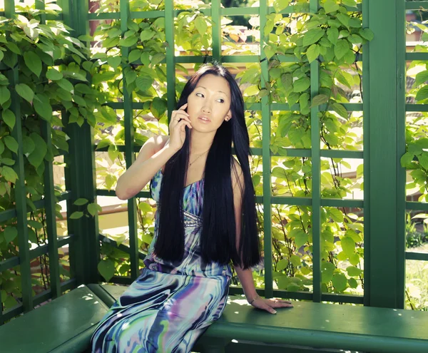 Asian woman sitting on the park bench — Stock Photo, Image