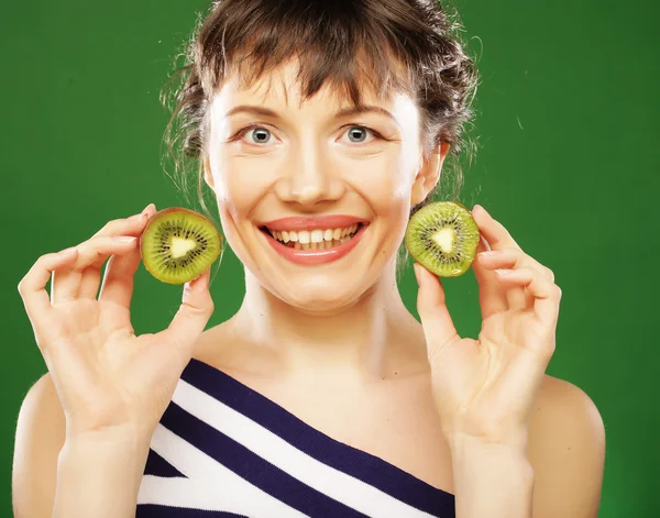 Jovem mulher sorridente segurando kiwi . — Fotografia de Stock