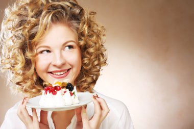 Elinde pasta olan genç bir kadın.