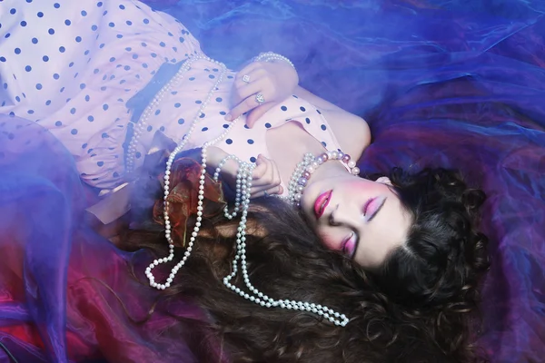 Kvinna liggande på organza med pärla — Stockfoto