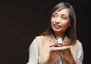 Elinde pasta olan genç bir kadın.