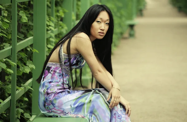 Aziatische vrouw zitten op de parkbank — Stockfoto
