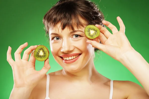 Joven mujer sonriente sosteniendo kiwi . — Foto de Stock