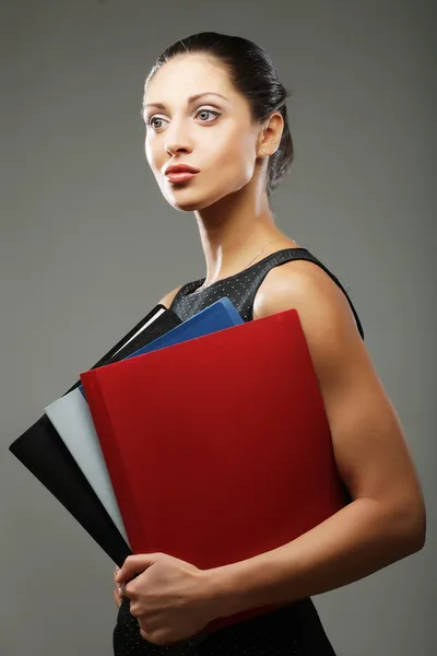 Vrouw met mappen over grijze achtergrond — Stockfoto