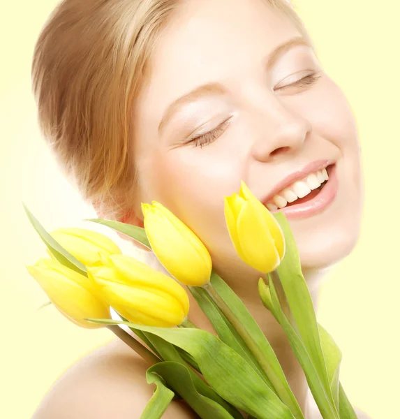 Giovane donna sorridente con tulipani gialli — Foto Stock