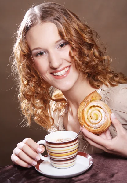 Женщина ест печенье и пьет кофе . — стоковое фото
