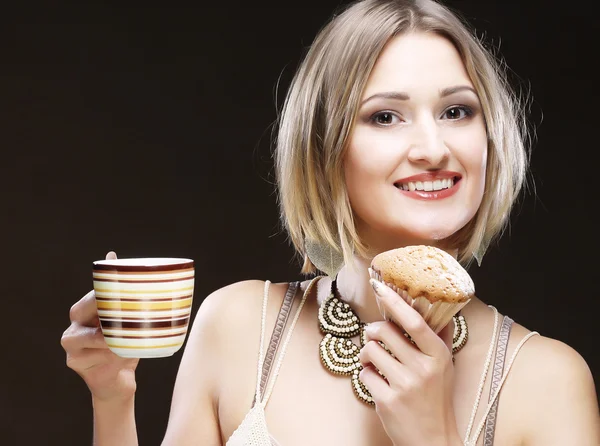 Woman eating cookie and drinking coffee. — Stock Photo, Image