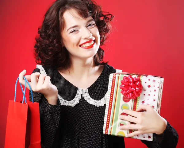 Happy woman with shopping bag and gift. — Stock Photo, Image