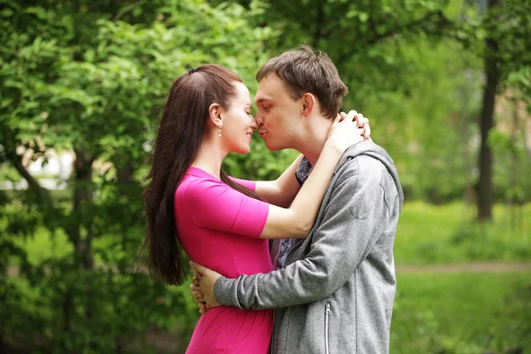 Young beautiful couple in a sweet cheek kiss — Stock Photo, Image