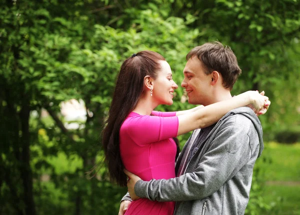 Young beautiful couple in a sweet cheek kiss — Stock Photo, Image