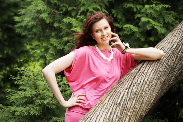 Giovane donna posa su un albero — Foto Stock