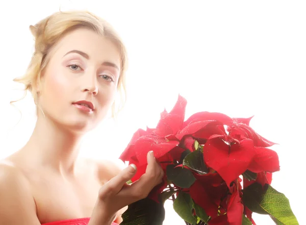 Nainen, jolla on punaisia joulukukkia — kuvapankkivalokuva