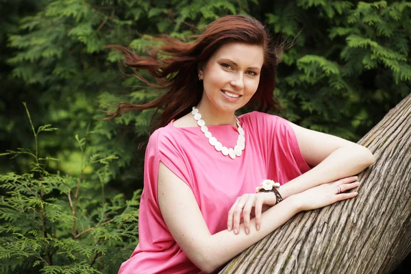 Jeune femme posant sur un arbre — Photo