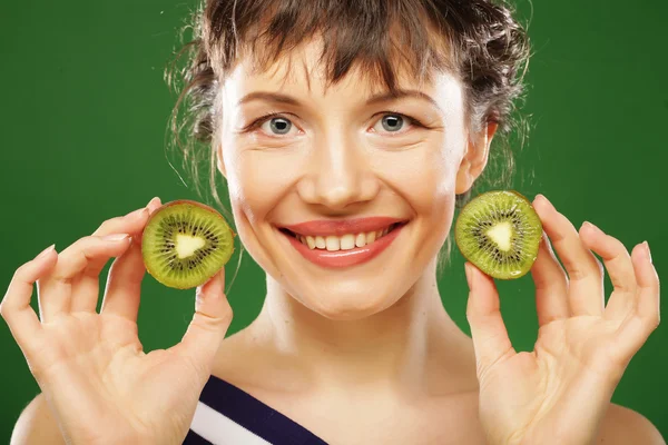 Jeune femme souriante tenant kiwi . — Photo