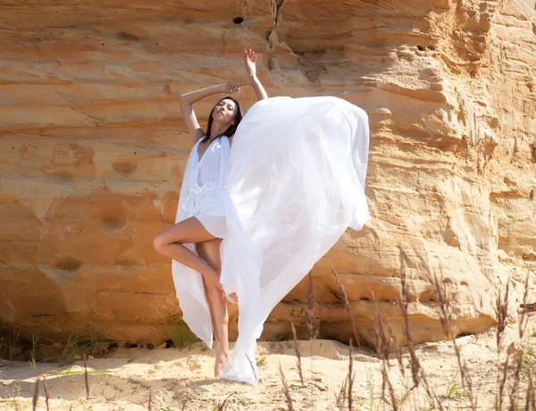Vrouw in witte jurk dansen op de woestijn — Stockfoto