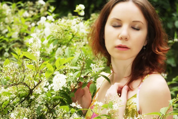 Woman with flowers posing in summer park — Stock Photo, Image