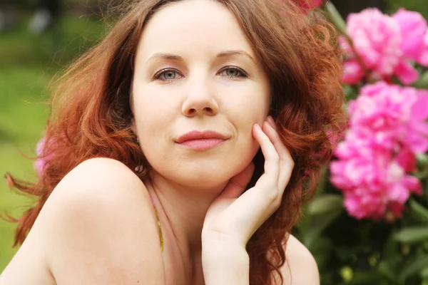 Mulher com flores posando no parque de verão — Fotografia de Stock