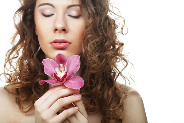 Schöne Frau mit rosa Orchidee — Stockfoto