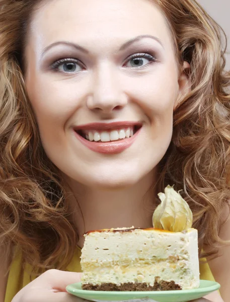 Jovem mulher segurando um delicioso pedaço de bolo — Fotografia de Stock