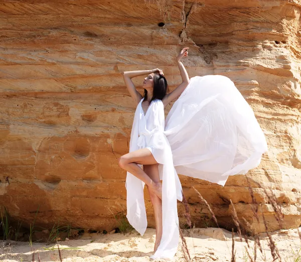 Frau in weißem Kleid tanzt in der Wüste — Stockfoto