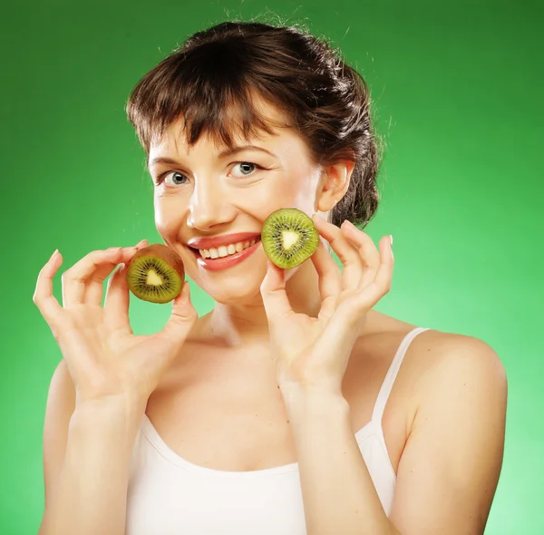 Jonge lachende vrouw bedrijf kiwi. — Stockfoto