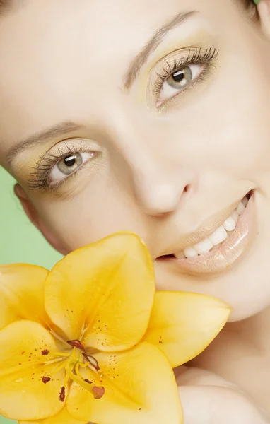 Mulher com flores amarelas no fundo verde — Fotografia de Stock