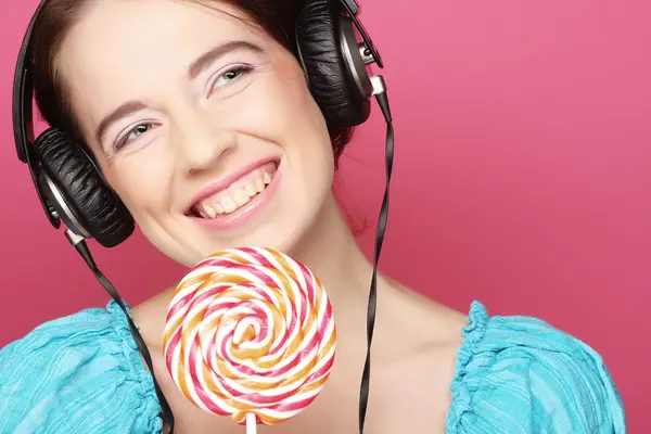 Schöne Frau mit Kopfhörern und Süßigkeiten — Stockfoto