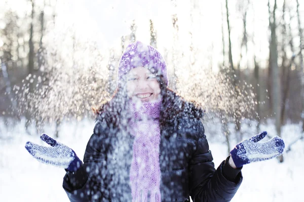 Mujer en el parque de invierno, soplando nieve juguetonamente —  Fotos de Stock