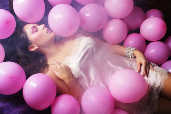 Sleeping woman lying on floor among balloons — Stock Photo, Image