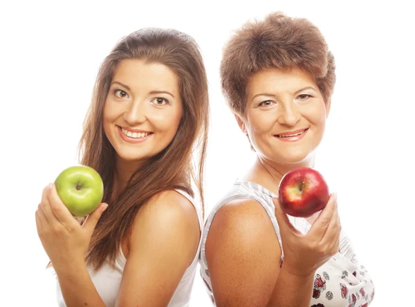 Frau mittleren Alters mit ihrer Tochter, die Äpfel hält — Stockfoto