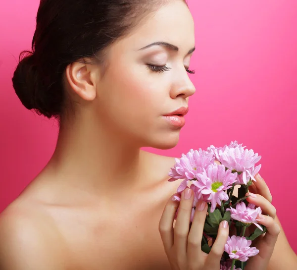 Junge Frau porträtiert mit rosa Chrysanthemen — Stockfoto