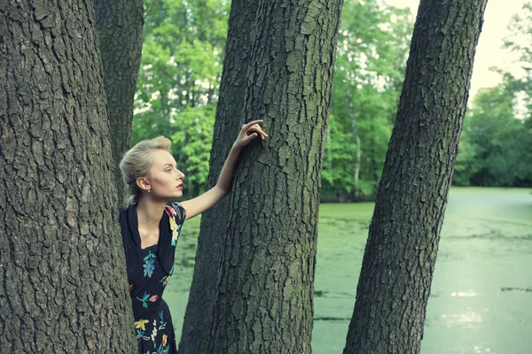 Jonge vrouw poseren op een boom — Stockfoto