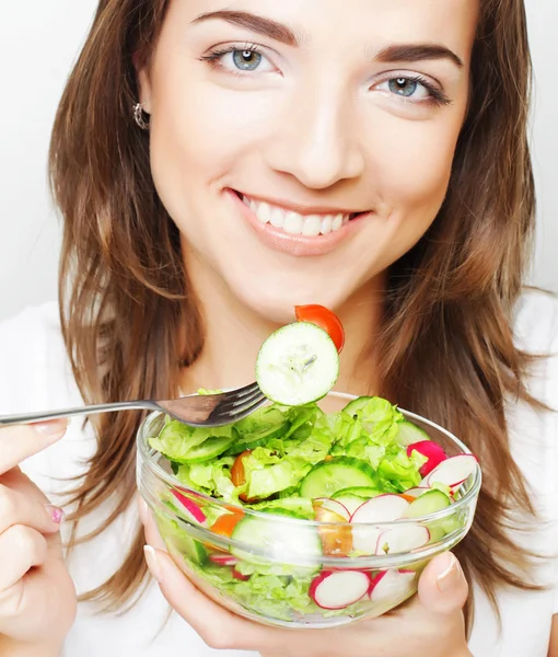Chica sonriente con ensalada sobre un fondo blanco — Foto de Stock