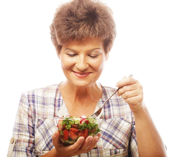 Mature smiling woman eating salad — Stock Photo, Image