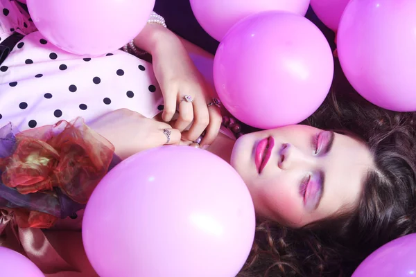 Sleeping woman lying on floor among balloons — Stock Photo, Image