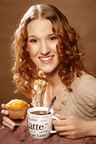 Vrouw cookie eten en drinken van koffie. — Stockfoto