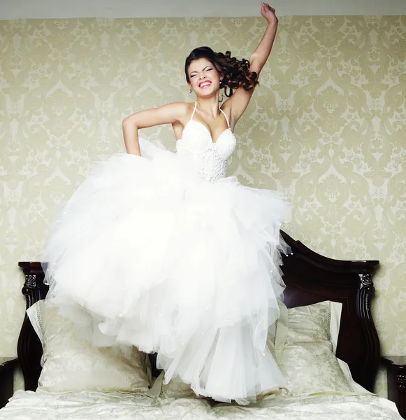 Joyeux saut de mariée sur le lit . — Photo