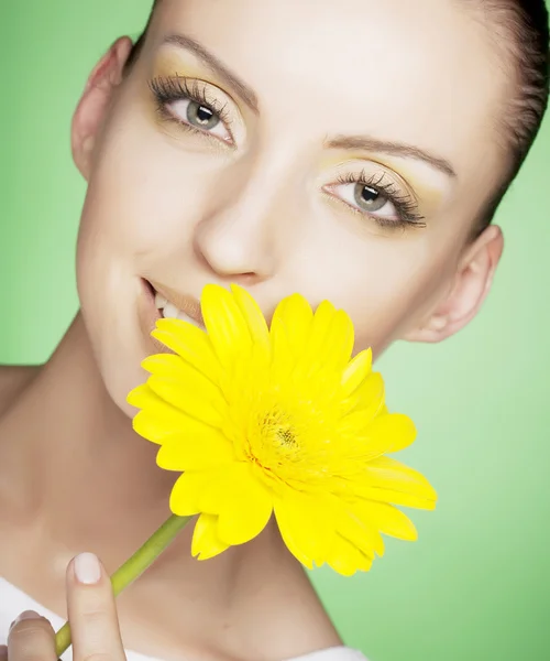 Frau mit gelben Blumen auf grünem Hintergrund — Stockfoto