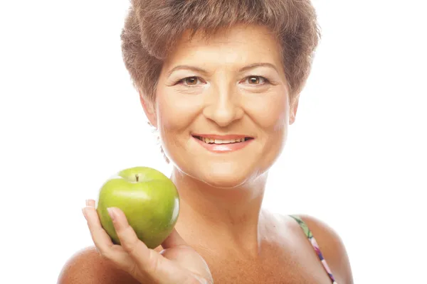 Reife lächelnde Frau mit grünem Apfel — Stockfoto