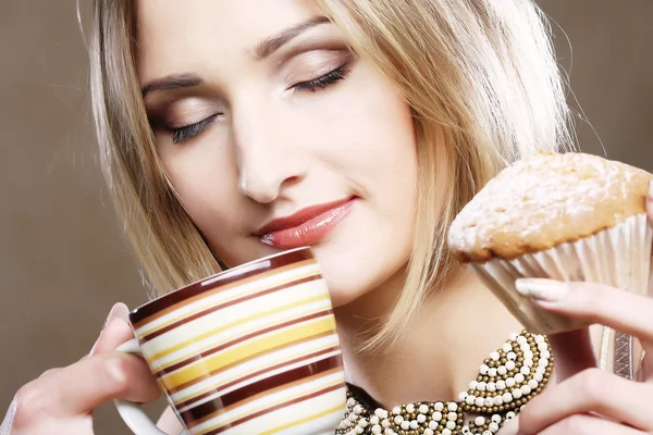 Woman eating cookie and drinking coffee. — Stock Photo, Image