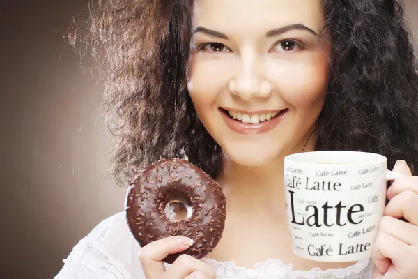 Mulher segurando donut e café na mão — Fotografia de Stock