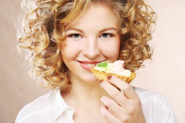 Elinde pasta olan genç bir kadın.