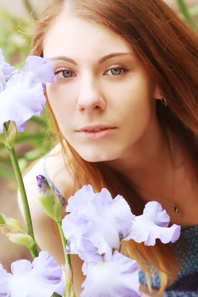 Frau mit Blumen posiert im Sommerpark — Stockfoto
