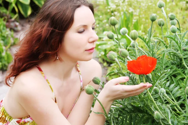 Femme avec des fleurs posant dans le parc d'été — Photo